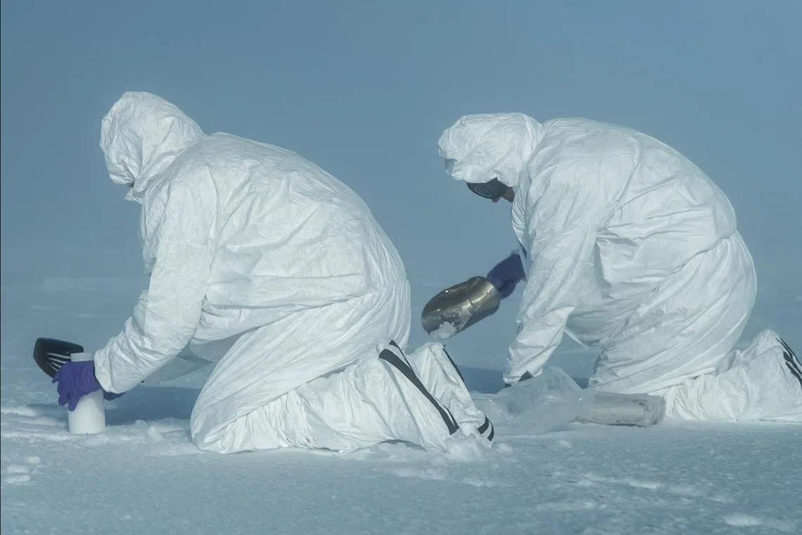 Felicity Aston scooping surface snow to sample for microplastics