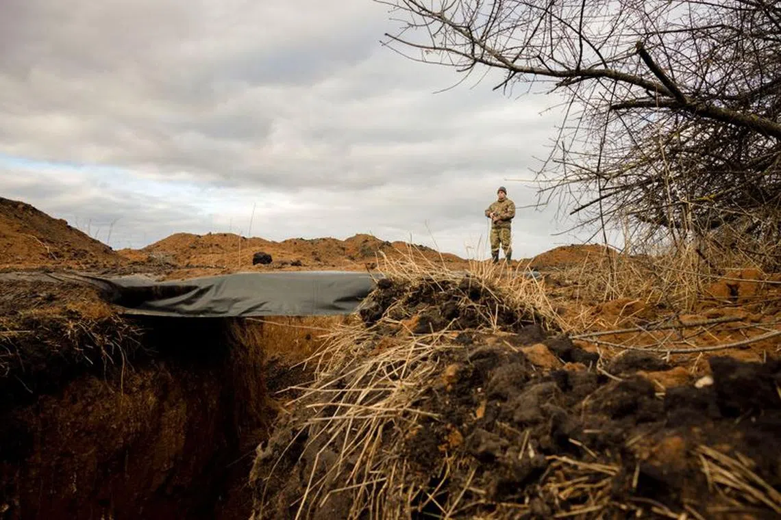 A Ukrainian soldier keeps watch at a freshly dug trench that his unit built as part of a system of new fortifications near the front lines outside Kupiansk, amid Russia’s attack on Ukraine, December 28, 2023.  REUTERS/Thomas Peter/File Photo