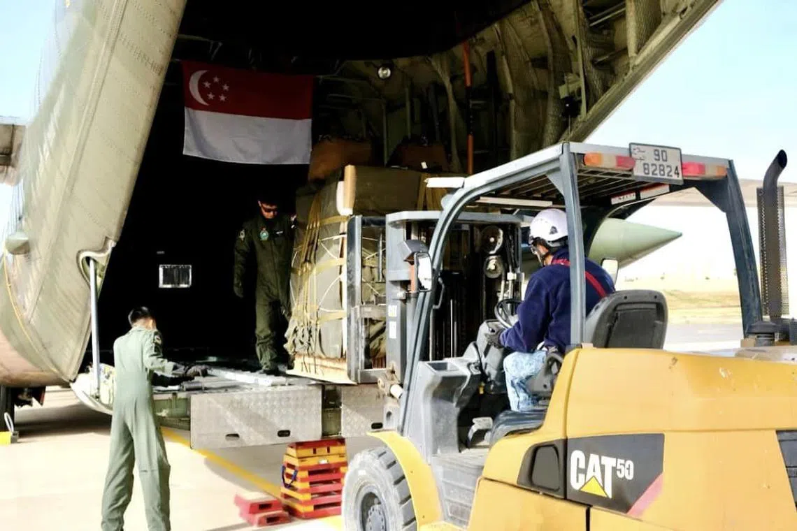 After attaching the parachutes, the airdrop supplies are loaded onto our C-130 transport aircraft.