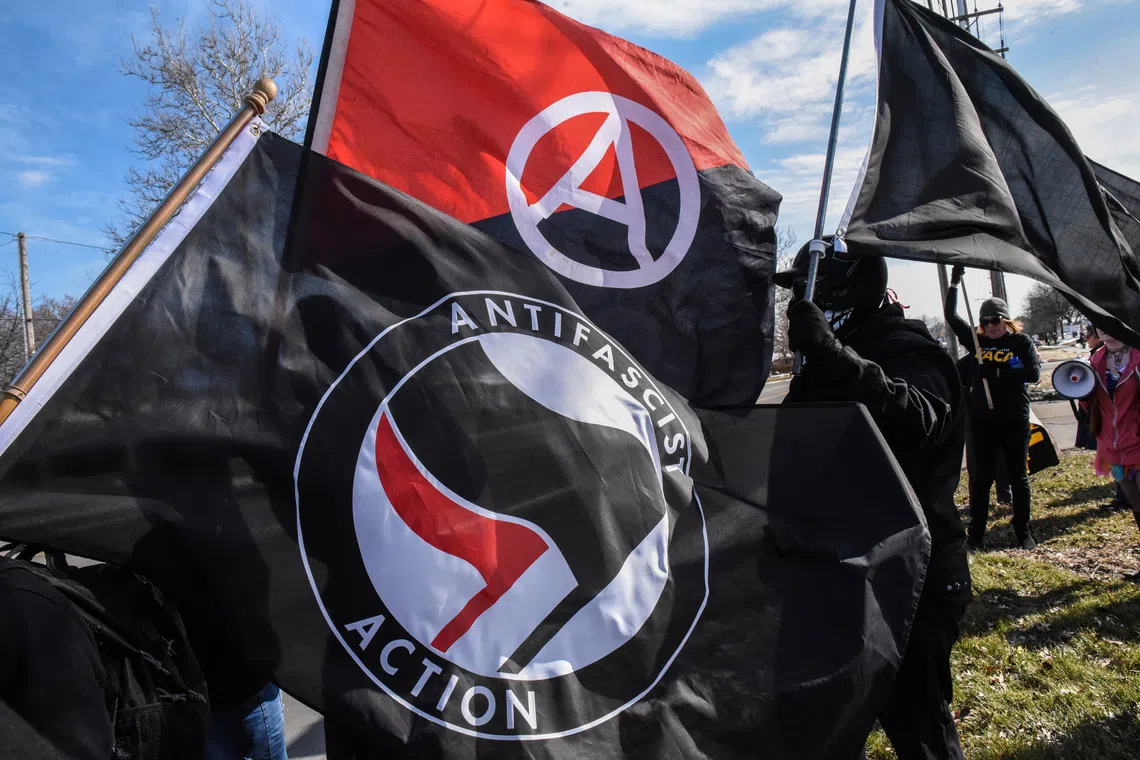 FILE PHOTO: Members of the Great Lakes anti-fascist organization (Antifa) fly flags during a protest against the Alt-right outside a hotel in Warren, Michigan, U.S., March 4, 2018. REUTERS/Stephanie Keith/File Photo