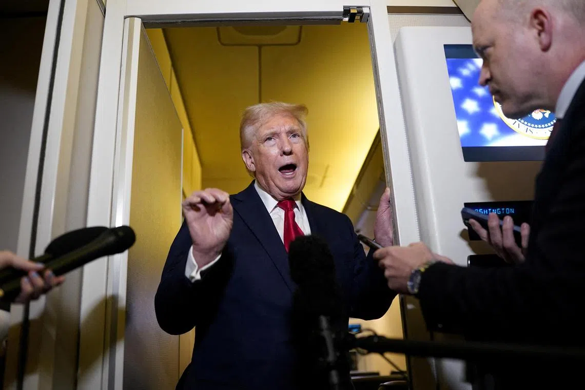 US President Donald Trump speaks to members of the media onboard Air Force One, on a flight to Joint Base Andrews in Maryland, US, April 13, 2025. 