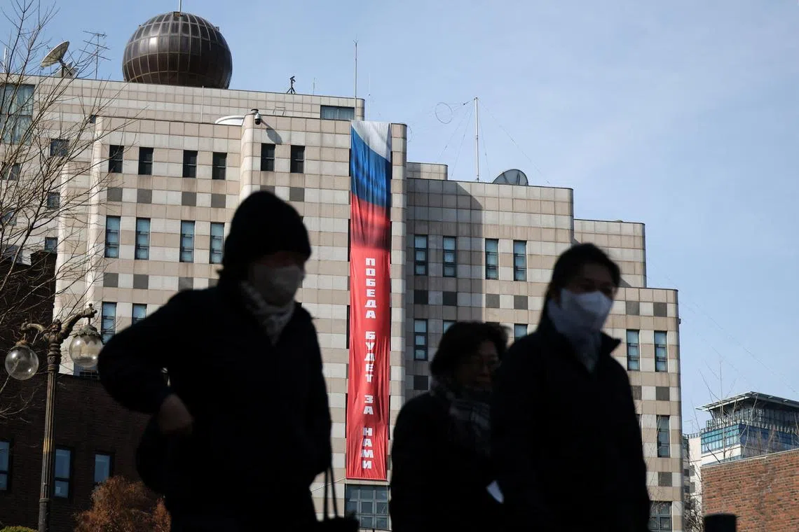 People walk past a banner that reads \"Victory will be ours,\" hanging on the exterior of the Russian Embassy, ahead of the fourth anniversary of Russia’s invasion of Ukraine, in Seoul, South Korea, February 23, 2026. REUTERS/Kim Hong-Ji