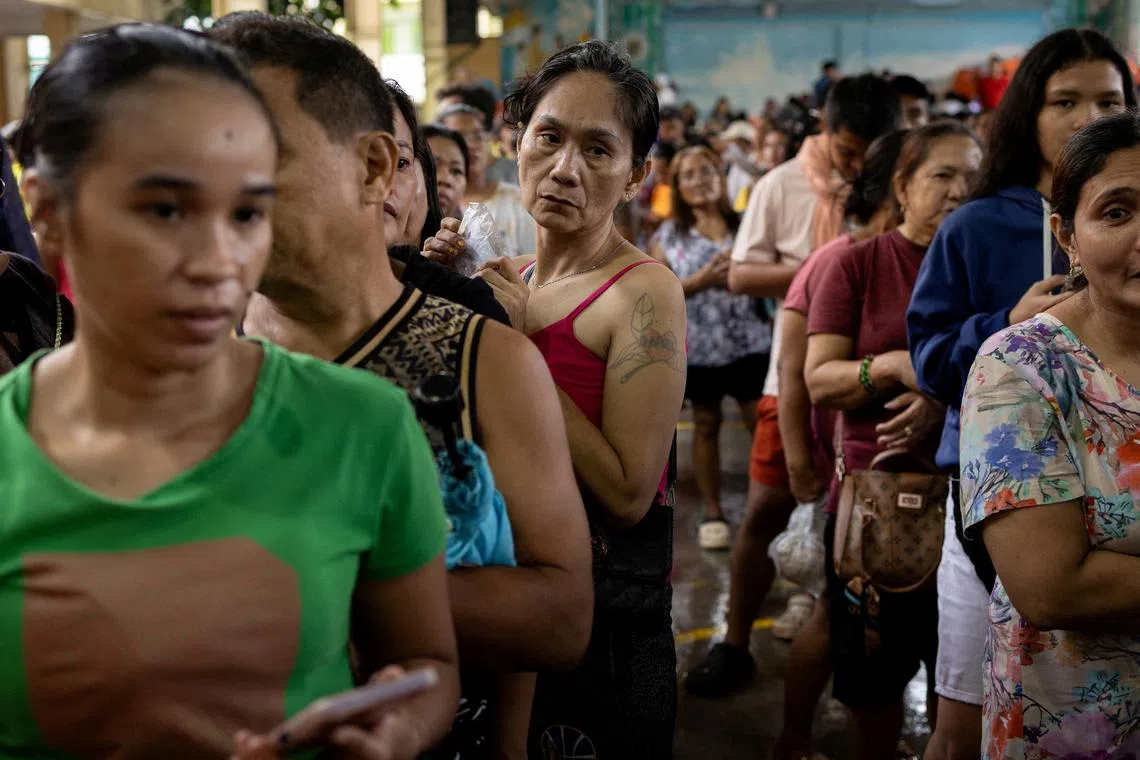 Residents affected by monsoon rains queuig for relief at a school-turned-evacuation centre in Quezon City, Philippines, July 23, 2025. 