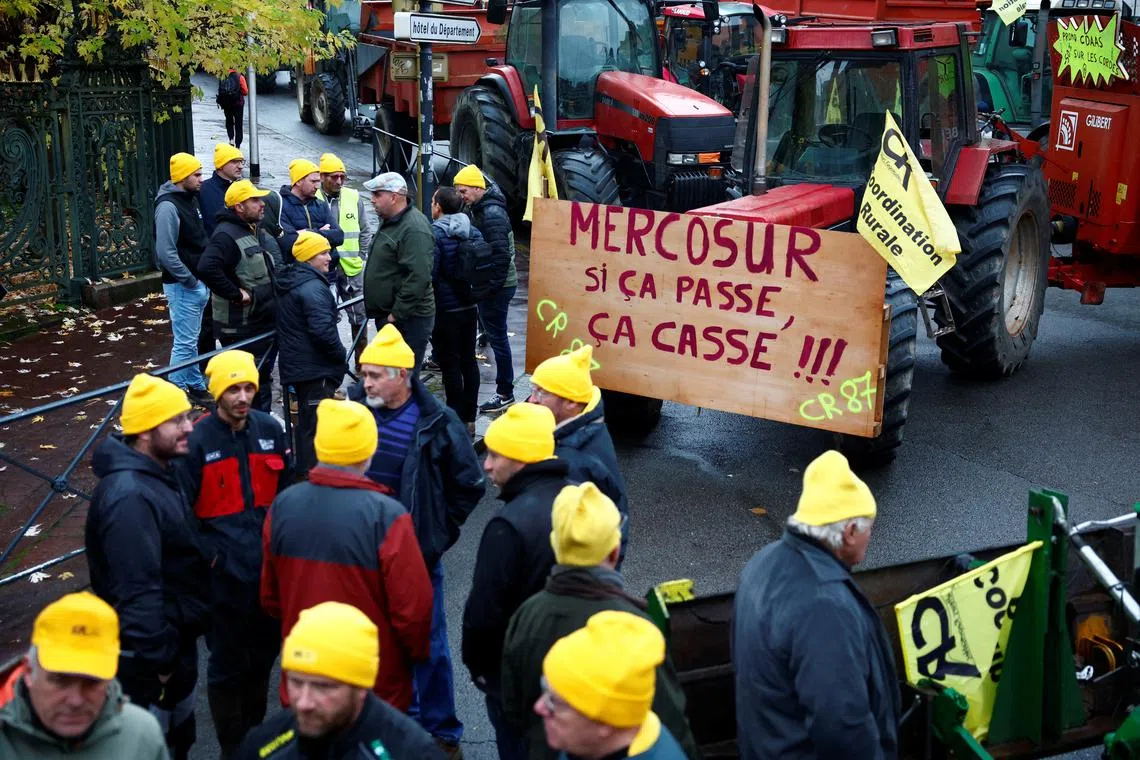 French farmers gather with their tractors in front of the Haute-Vienne Prefecture to protest against the prospect of a trade agreement between the European Union (EU) and the Latin American countries united within Mercosur, and demand more social aid amid a rain-hit harvests and disease outbreaks, in Limoges, France, November 19, 2024. The slogan reads \"Mercosur, if it passes, there will be trouble\".  REUTERS/Stephane Mahe