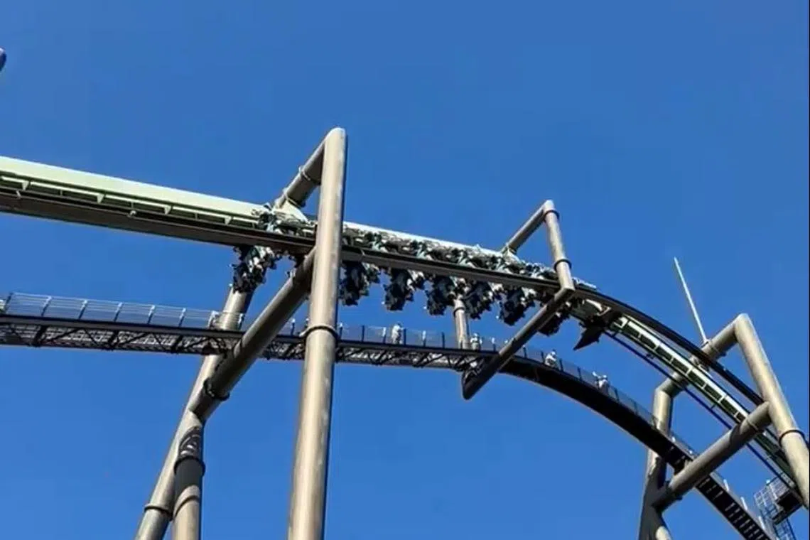 A carriage of the Flying Dinosaur roller coaster ride stopped at one of the course’s highest points at around 11am (10am in Singapore).