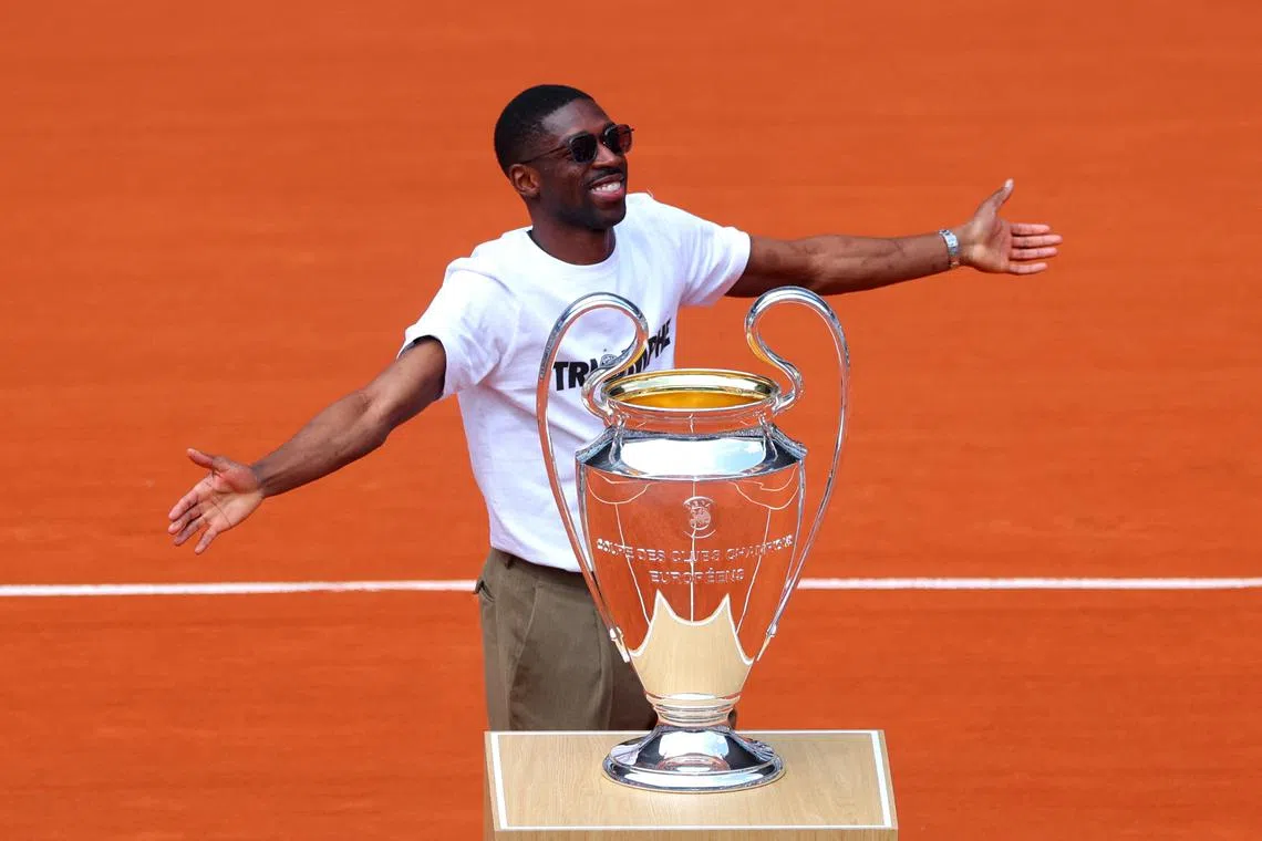 Tennis - French Open - Roland Garros, Paris, France - June 2, 2025 Paris St Germain's Ousmane Dembele presents the Champions League trophy on the Philippe-Chatrier court before the fourth round match betrween Serbia's Novak Djokovic and Britain's Cameron Norrie REUTERS/Denis Balibouse