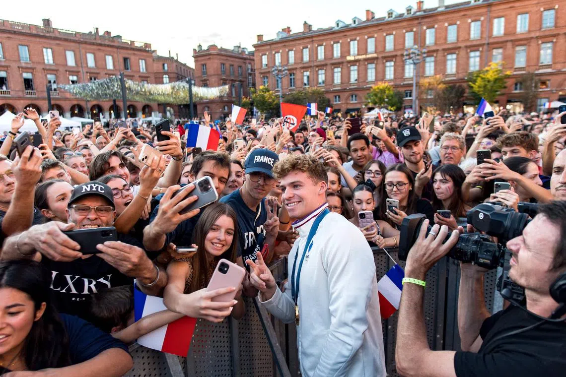 Leon Marchand, four-times gold medallist French swimmer celebrates with the people of Toulouse during a ceremony for Toulouse's Olympic medallists in the Place de Capitole, in Toulouse, southwestern France, on september 18, 2024. (Photo by Matthieu RONDEL / AFP)