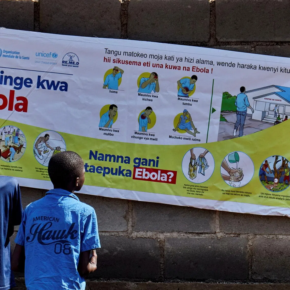 Congolese children Ibrah Asimwe and Alex Uketi read an advocacy poster as aid agencies intensify efforts to contain a new Ebola outbreak involving the Bundibugyo strain outbreak, in Bunia, Ituri province, Democratic Republic of Congo, May 20, 2026. REUTERS/Gradel Muyisa Mumbere/