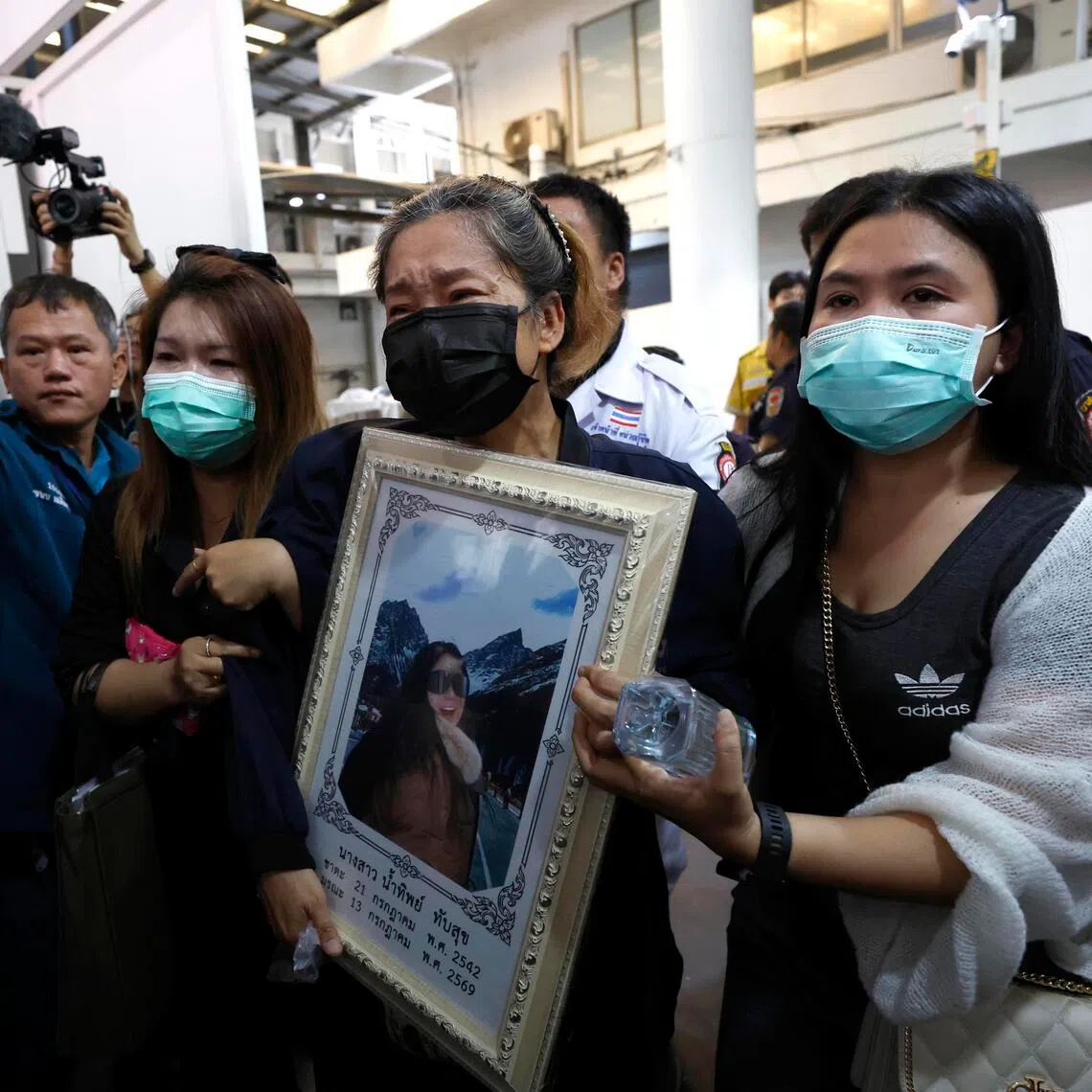 Family members break into tears as they collect the body of a woman who died with her husband in a pub fire at the Rong Beer Na Lat Phrao pub in Bangkok, Thailand.