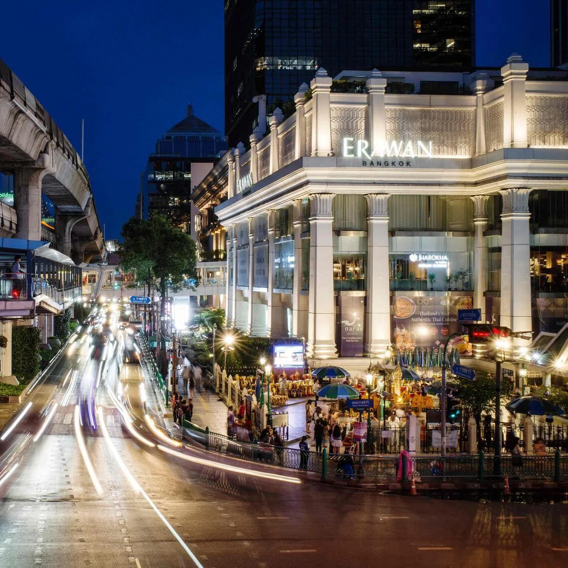 Cars drive past the Buddhist Erawan Shrine (right) in Bangkok on June 9. 