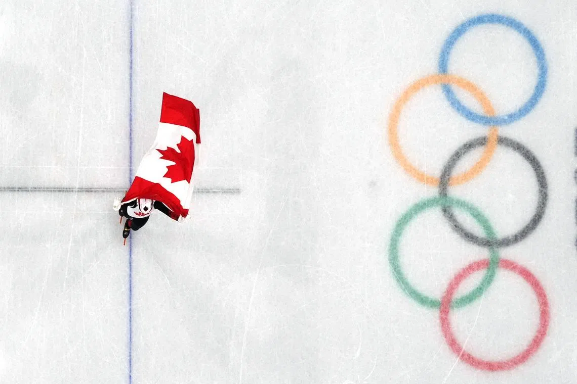 Milano Cortina 2026 Olympics - Short Track Speed Skating - Women's 1000m - Finals - Milano Ice Skating Arena, Milan, Italy - February 16, 2026. Courtney Sarault of Canada celebrates with her national flag after winning silver in the Women's 1000m Finals REUTERS/Fabrizio Bensch