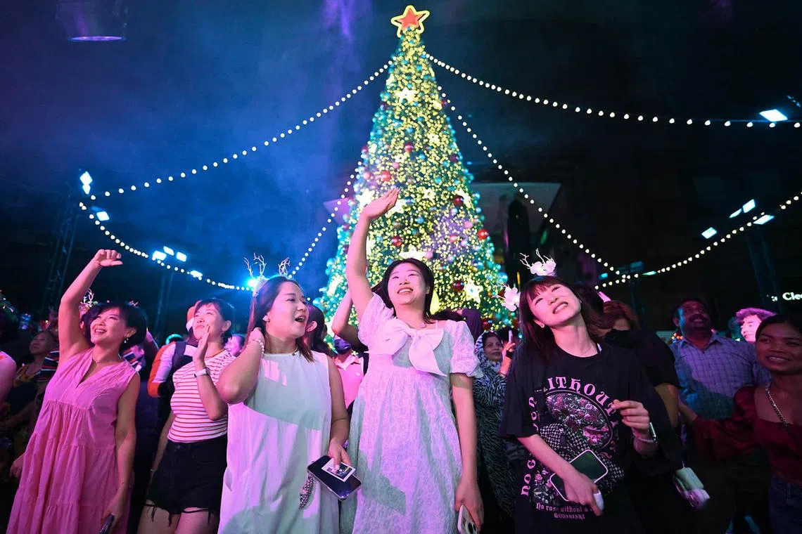 Revellers celebrating in front of a 14m-tall Christmas tree at Ngee Ann City Civic Plaza on Dec 24, 2024, during the Great Christmas Eve Street Party that stretched 400m from ION Orchard to Ngee Ann City. 