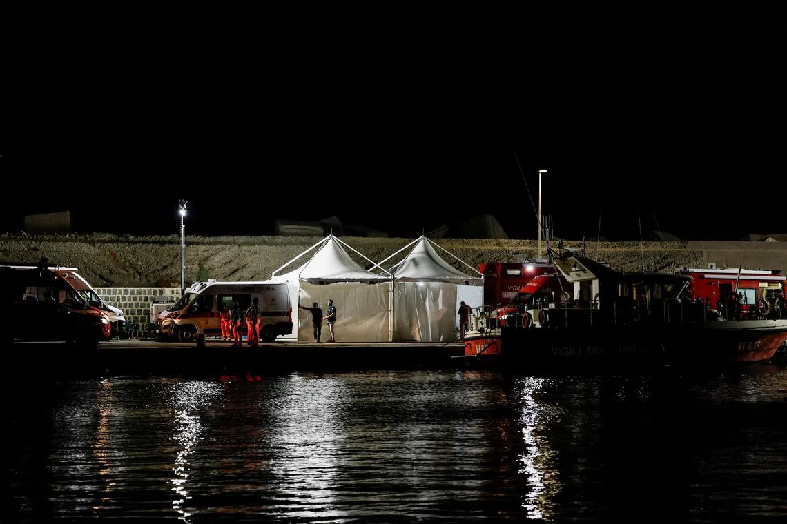Emergency and rescue service officials work at a port near the site where a luxury yacht sank, in Porticello, near the Sicilian city of Palermo, Italy.