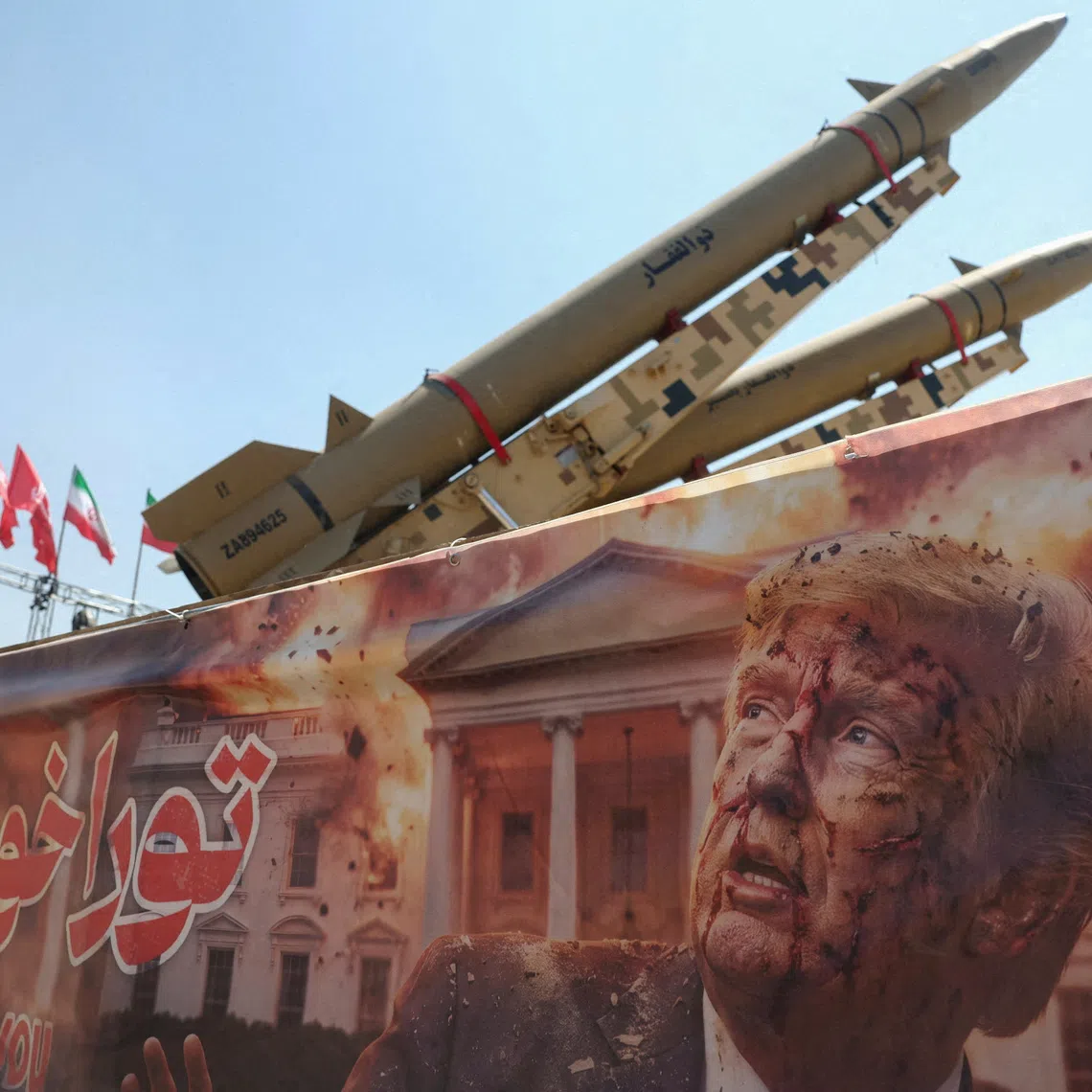 A banner with a picture of US President Donald Trump next to an Iranian missile system is seen at Azadi Square in Tehran.