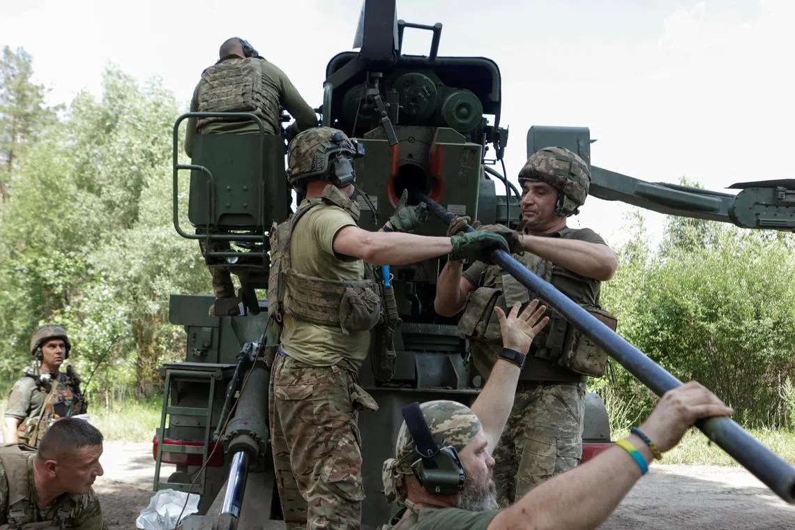 Ukrainian servicemen loading a shell into a self-propelled howitzer before firing towards Russian troops, in Ukraine's Kharkiv region, on July 27.