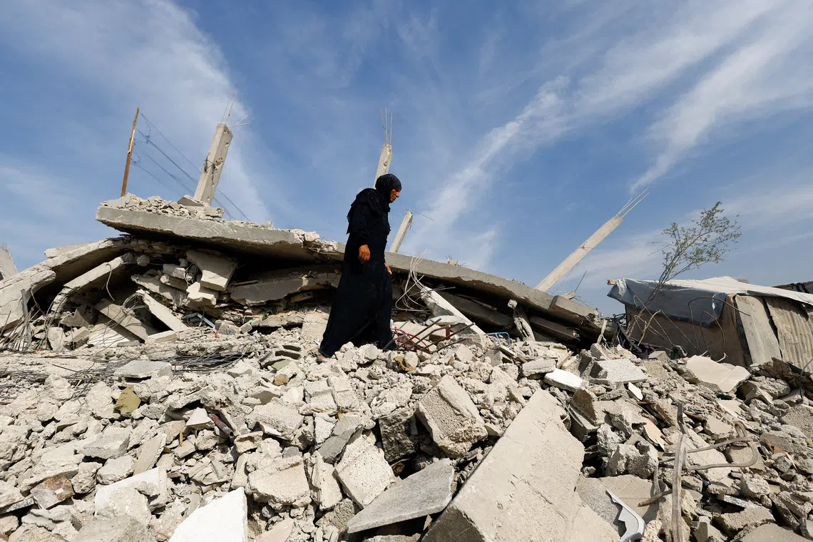 A Palestinian woman walks through the rubble of destroyed buildings, amid a ceasefire between Israel and Hamas, in Gaza City, November 2, 2025. REUTERS/Mahmoud Issa     TPX IMAGES OF THE DAY