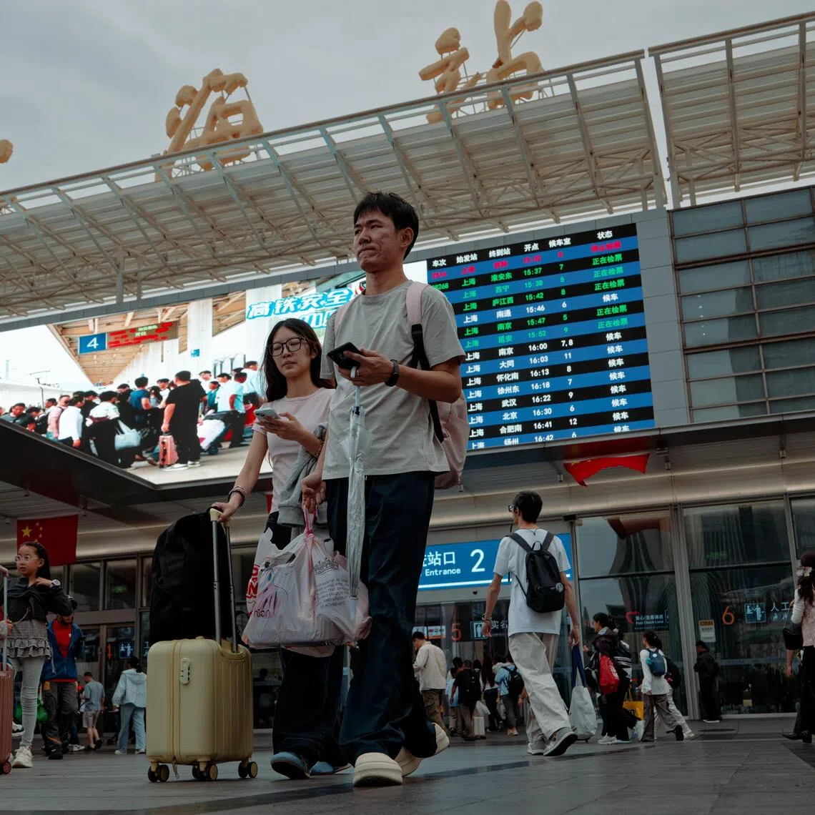 epa13274231 Travelers walk at a railway station during China's National Day holiday travel rush in Shanghai, China, 01 October 2026. The National Day holiday runs from 01 to 07 October 2026, a period of increased domestic travel across China. According to China's Ministry of Transport, about 2.13 billion cross-regional trips are expected during the seven-day holiday.  EPA/ALEX PLAVEVSKI
