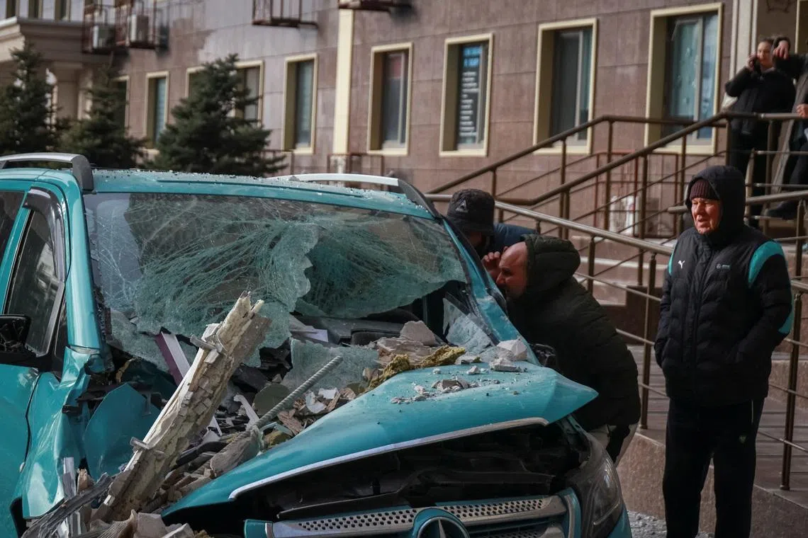 Residents observe a damaged car at the site of the Russian drone strike, amid Russia's attack on Ukraine, in Odesa, Ukraine January 19, 2026. REUTERS/Nina Liashonok