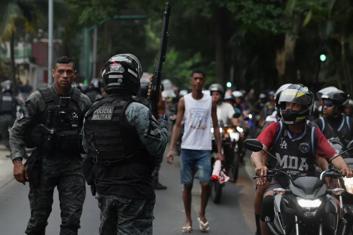 Law enforcement officers standing guard as residents demonstrate outside the government palace, a day after a deadly police operation against drug trafficking in Rio de Janeiro, on Oct 29.