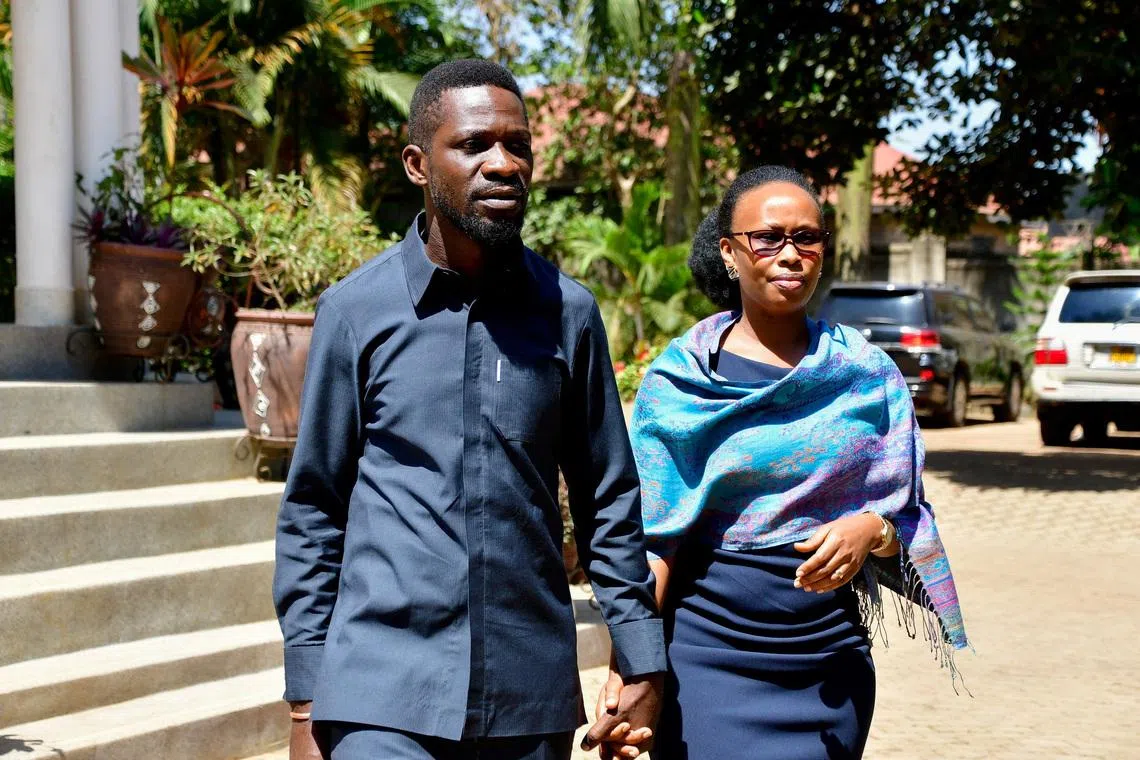 FILE PHOTO: Ugandan Presidential candidate Robert Kyagulanyi, also known as Bobi Wine, of the National Unity Platform (NUP) party, walks with his wife Barbara Kyagulanyi, after he addressed a press conference as they prepare to leave their Magere home to vote in the general election, in Kasangati town near Kampala, Uganda January 15, 2026. REUTERS/Abubaker Lubowa/ File Photo