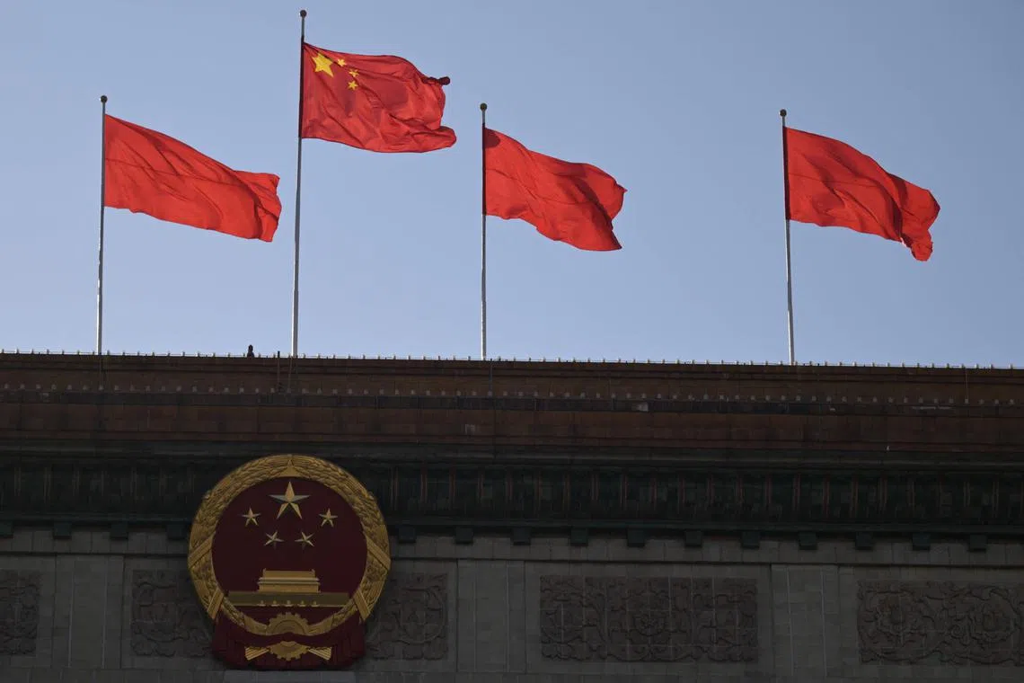 Chinese flags flutter atop the Great Hall of the People in Beijing on March 3, 2024, ahead of the country's annual legislative meetings known as the "Two Sessions". (Photo by Pedro Pardo / AFP)
