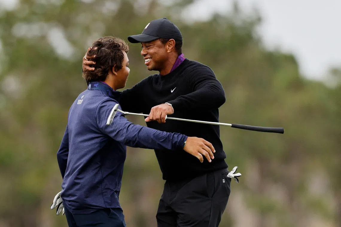 Tiger and Charlie Woods hug after finishing on the 18th green during the pro-am prior to the PNC Championship.
