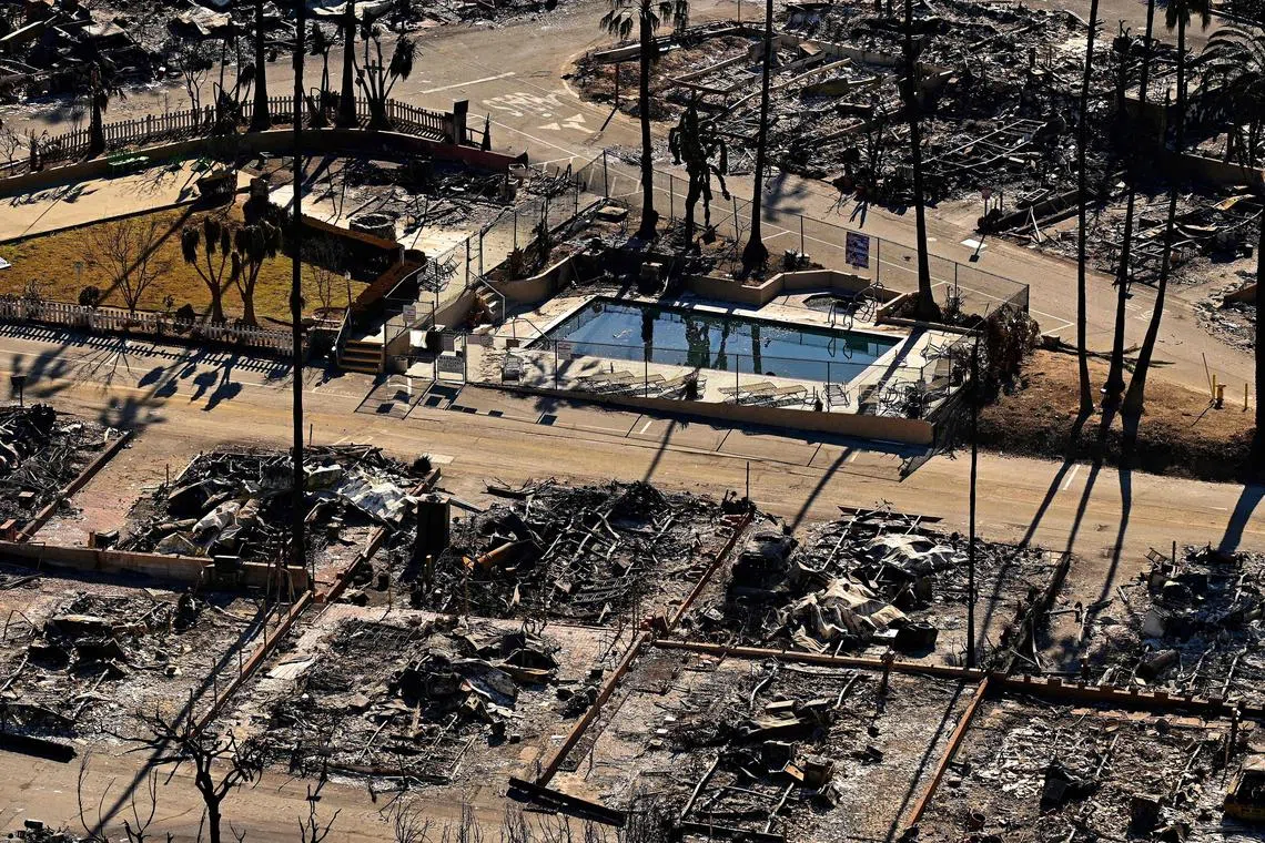 A swimming pool sits amid charred homes and burnt cars in the rubble of the fire-ravaged Pacific Palisades Bowl Mobile Estates in Los Angeles.