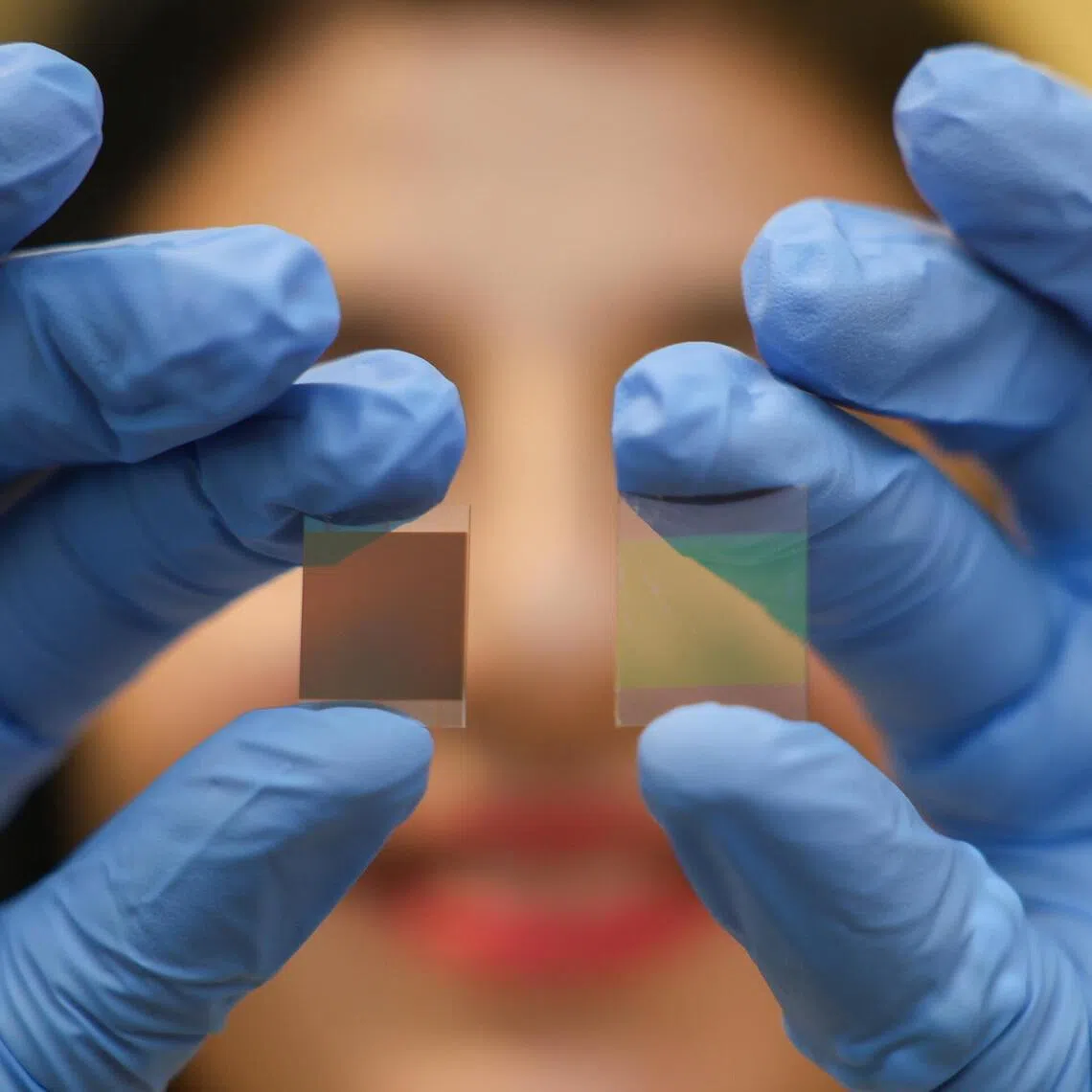 Associate Professor Annalisa Bruno, from the School of Physical and Mathematical Sciences and School of Materials Science and Engineering at NTU, holding up a 400nm film (left) and a 10nm film that was developed by researchers at the Energy Research Institute @ NTU.