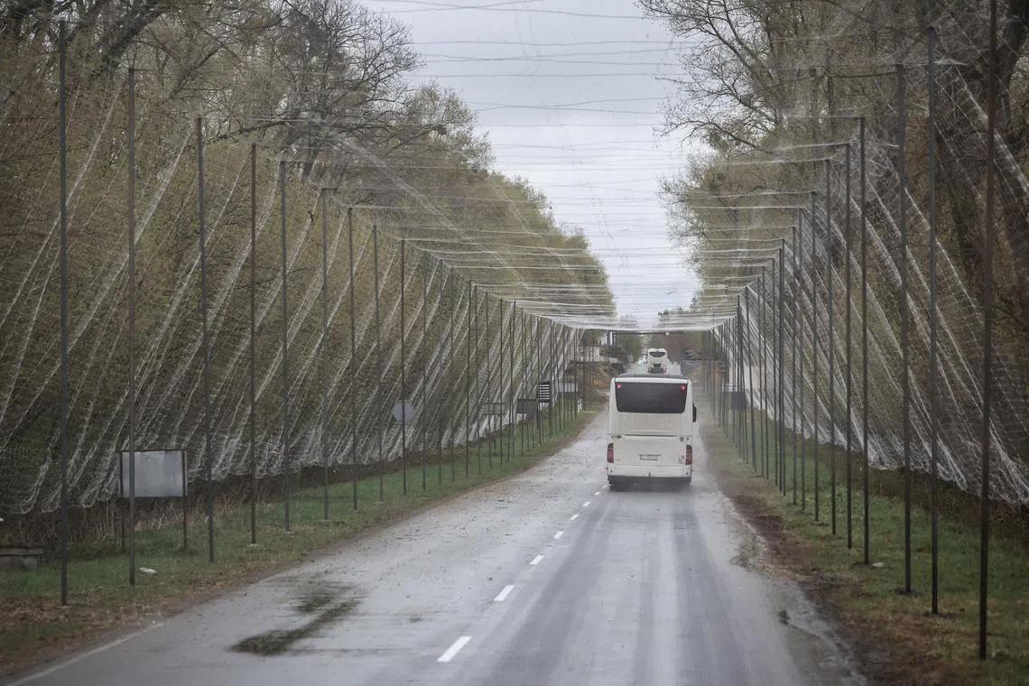 A bus drives on a road covered with anti-drone net near the Chornobyl Nuclear Power Plant, amid Russia's attack on Ukraine, in Kyiv region, Ukraine April 26, 2026. REUTERS/Alina Smutko/File Photo
