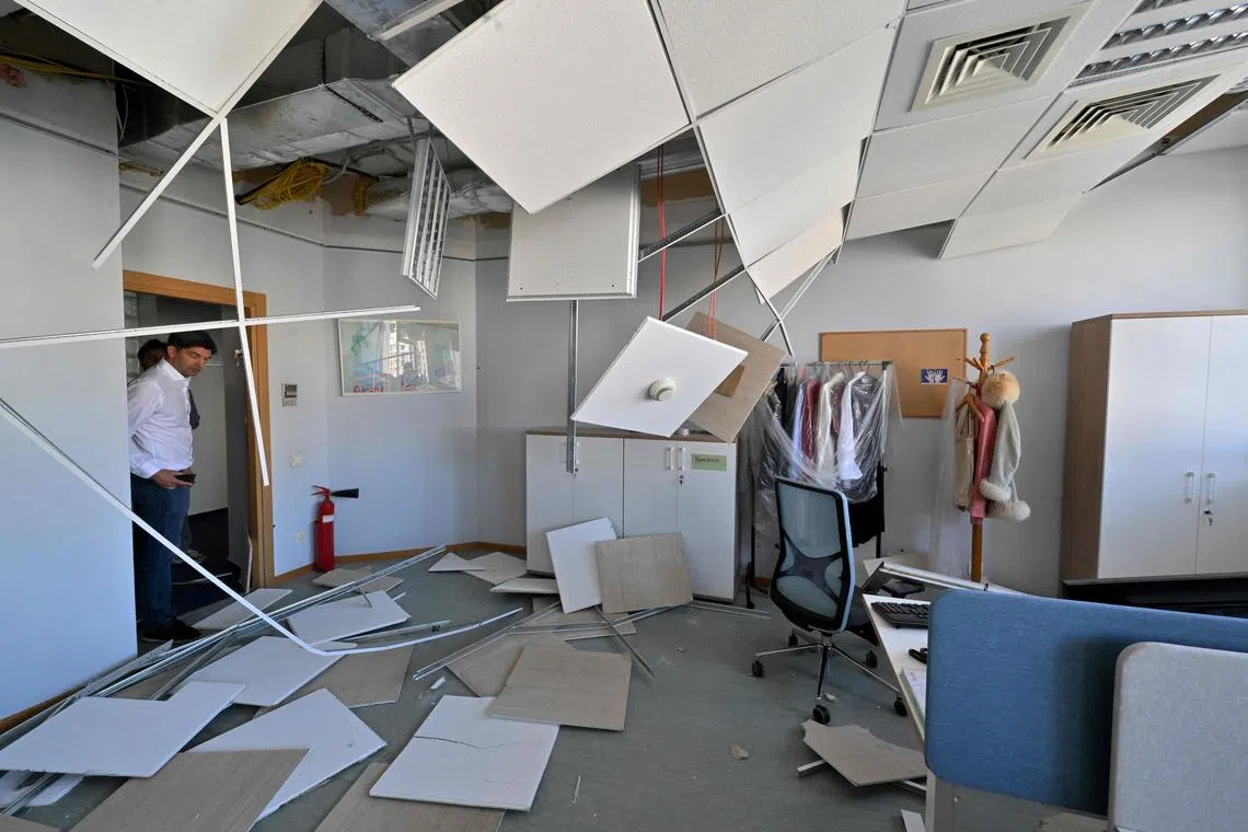 A EU employee watch damages in the offices of the European Union delegation in Ukraine after a Russian missile and drone attack. 