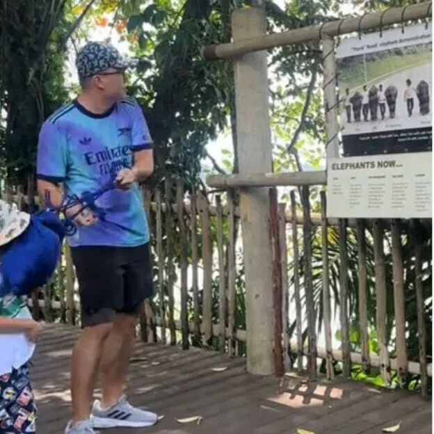 The video showed a man swinging a bag at a macaque at the Singapore Zoo. He misses the animal, with the bag hitting his child in the face instead.