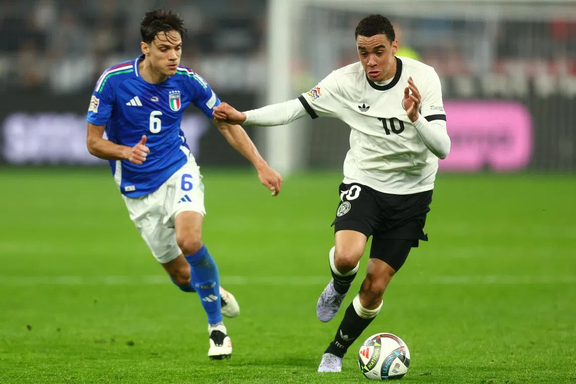 Soccer Football - Nations League - Quarter Final - Second Leg - Germany v Italy - Signal Iduna Park, Dortmund, Germany - March 23, 2025 Germany's Jamal Musiala in action with Italy's Samuele Ricci REUTERS/Leon Kuegeler
