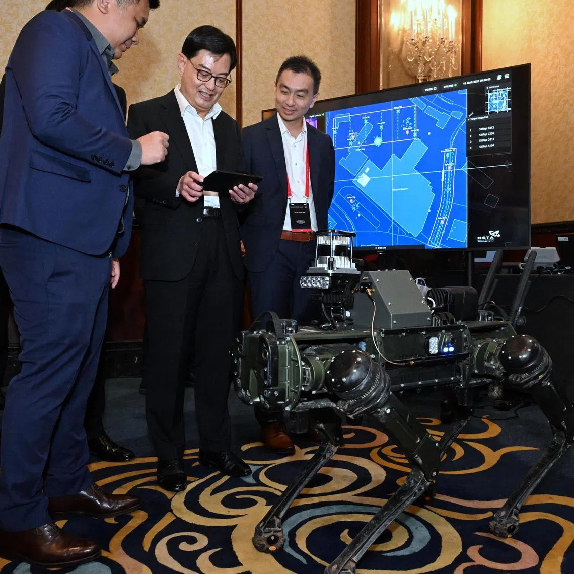 DPM Heng Swee Keat trying his hand at controlling the legged robot using DSTA?s robotics-enabled C3 at the Singapore Defence Technology Summit on March 19, 2025.