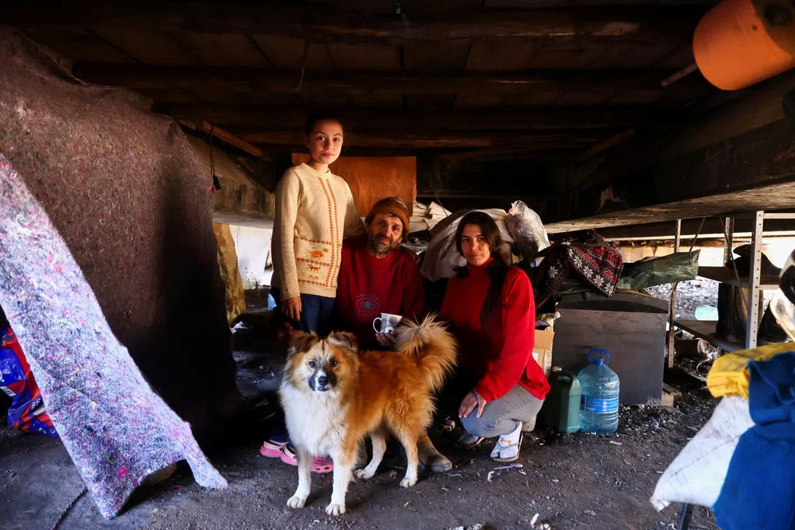 Milton do Nascimento, alongside his wife Gabriela de Freitas and stepdaughter Natalia da Silva, pose inside their temporary housing located under a bridge on BR-290, after their home was hit by the May flood, in Porto Alegre, Rio Grande do Sul, Brazil, August 27, 2024. REUTERS/Diego Vara