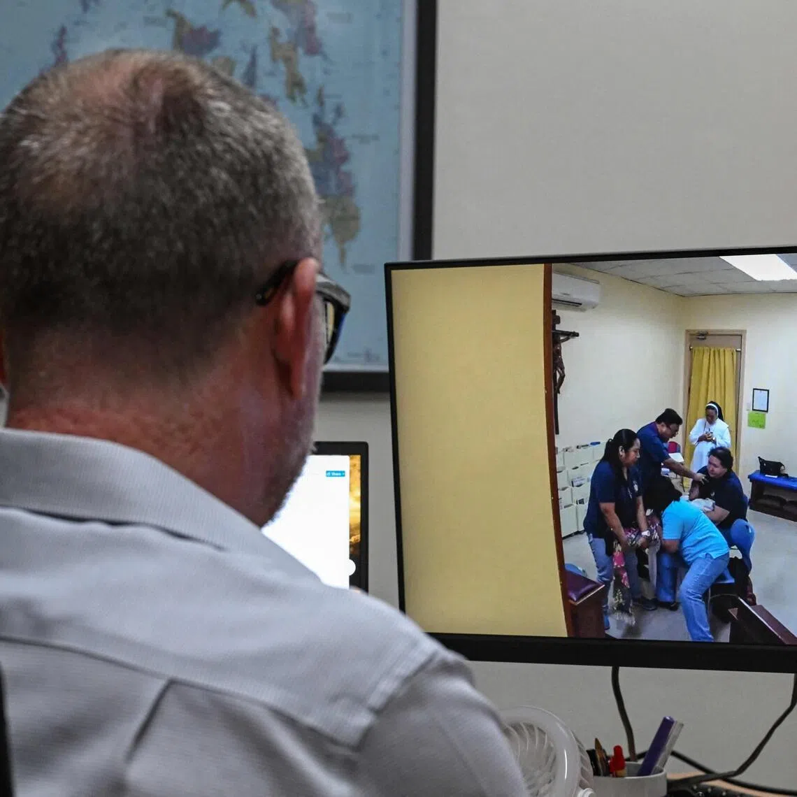 A man watching a footage of a woman being exorcised, in Makati, Metro Manila.