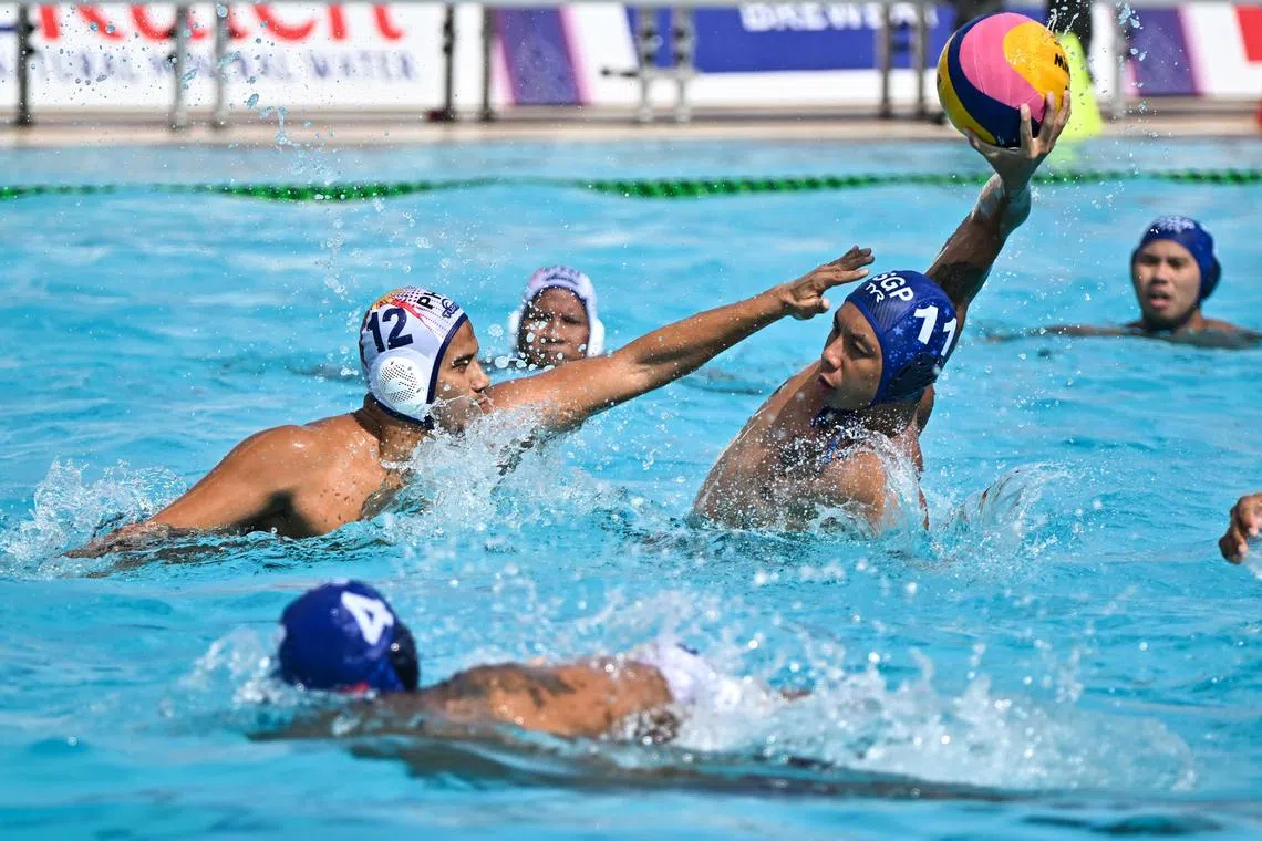 Yip Yang from Singapore (No. 11) going up against Juan Paolo Banaga Serrano from Philippines in the men's water polo round robin match at the SEA Games. Singapore won 10 - 4.