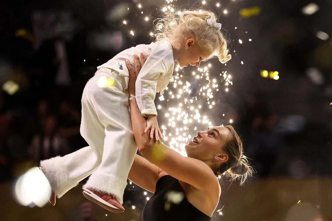 TOPSHOT - Belarus' Aryna Sabalenka interacts with her goddaughter Nicole during the trophy ceremony following her defeat in her Battle of the Sexes exhibition tennis match against Australia's Nick Kyrgios in Dubai on December 28, 2025. (Photo by Amr Alfiky / POOL / AFP)