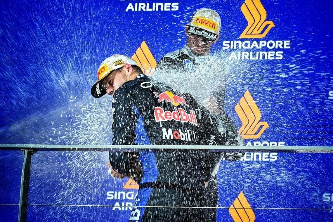 Red Bull’s Max Verstappen and Ferrari’s Charles Leclerc celebrate on the podium at the Singapore Grand Prix on Oct 11.