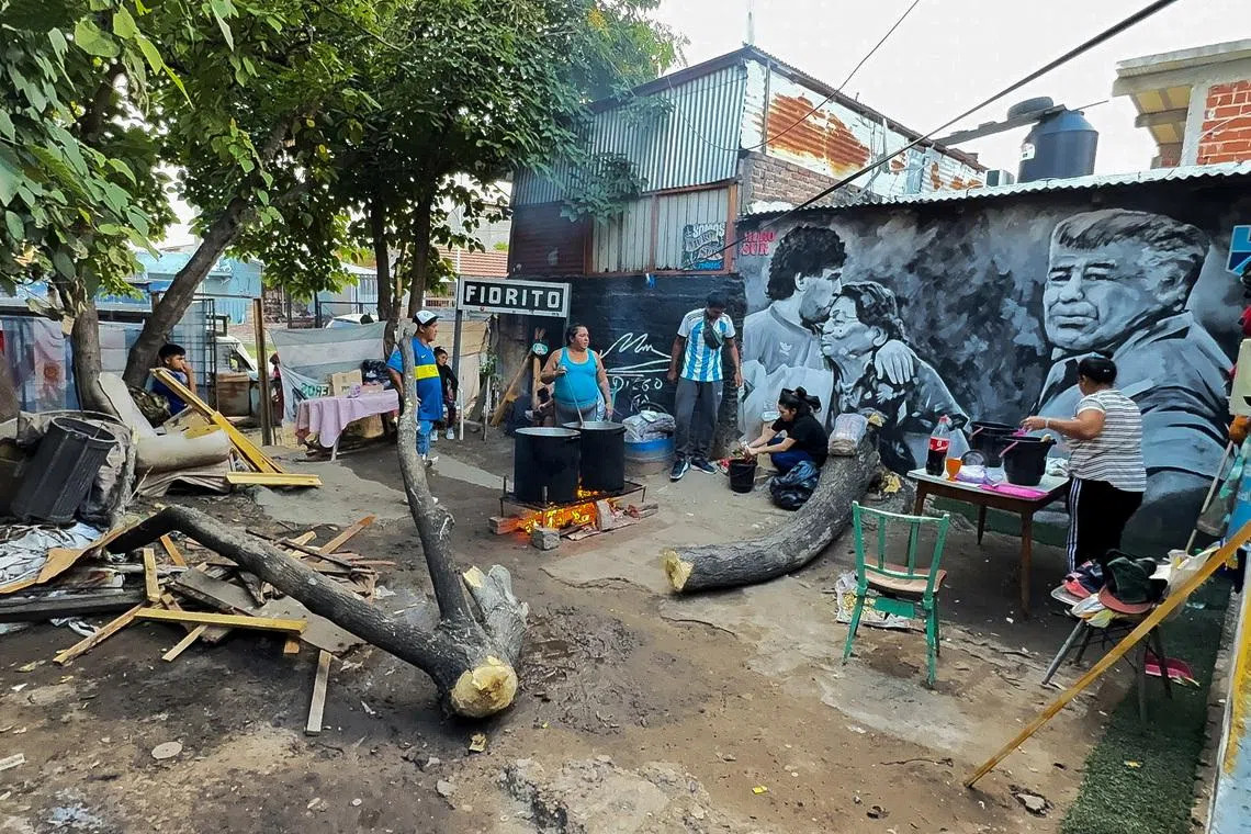 People cook stew for residents of the working-class neighbourhood of Villa Fiorito at a soup kitchen set up in the house where late soccer legend Diego Armando Maradona spent his early childhood, on the outskirts of Buenos Aires, Argentina, March 26, 2026. REUTERS/Miguel Lo Bianco