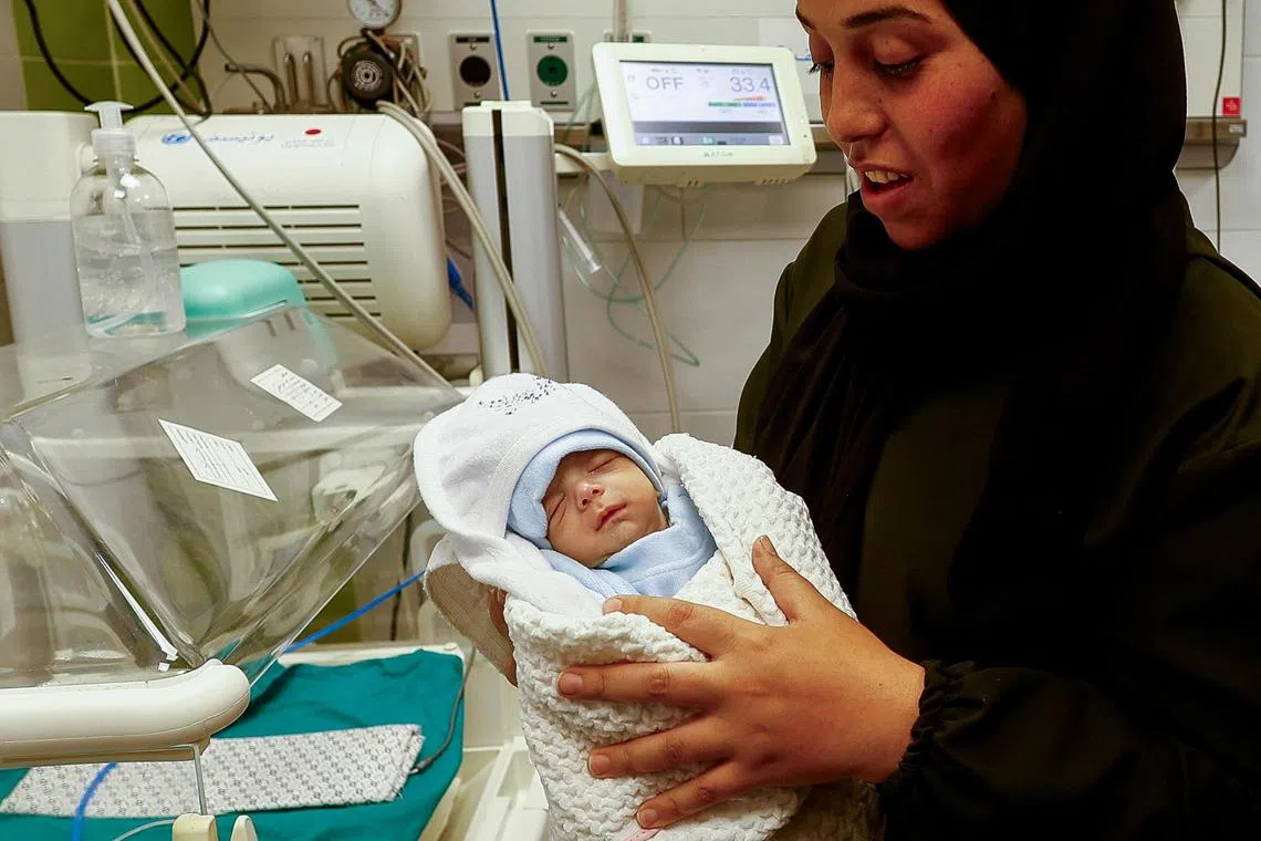 Palestinian mother Warda Sbeta holds her son, Anas, after being reunited with him at a hospital in Rafah, in the southern Gaza Strip.