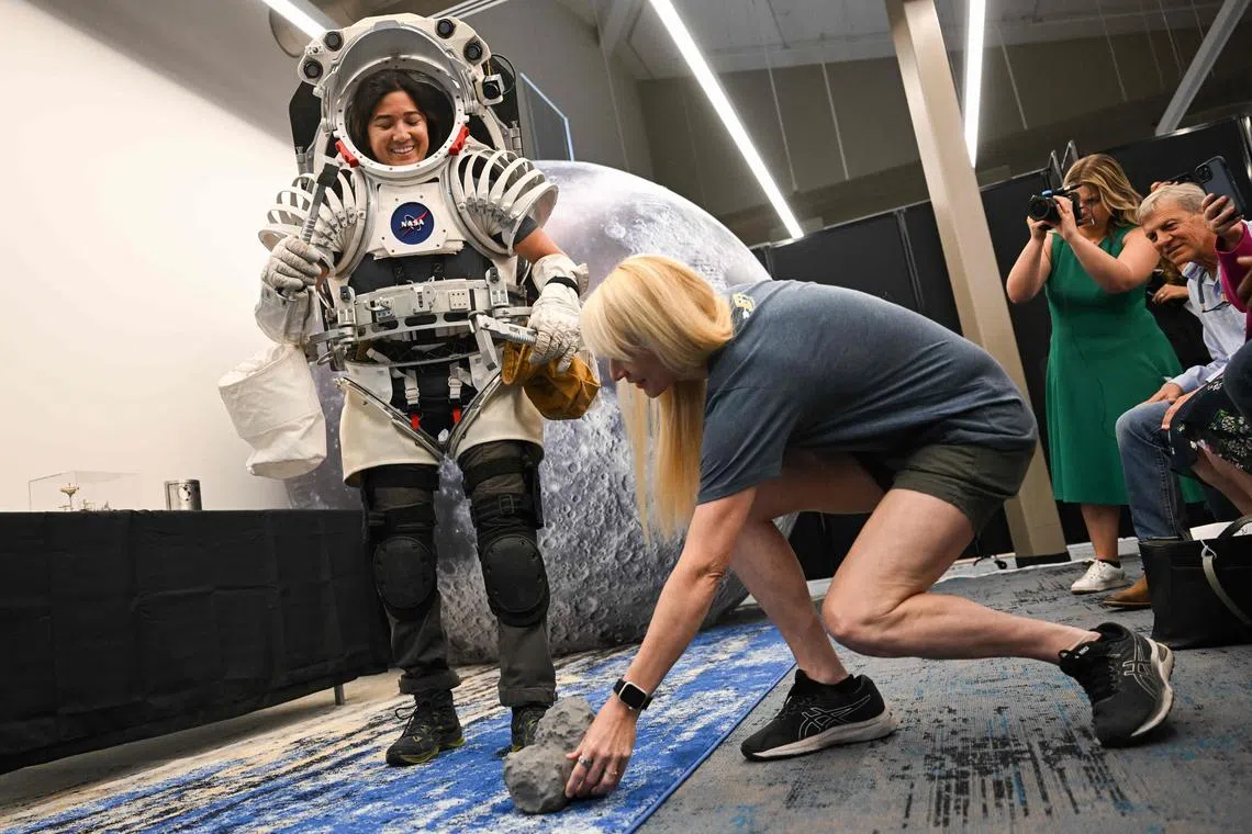 NASA astronaut Kate Rubins placing a demonstration moon rock for Angela Garcia, an exploration geologist at NASA Johnson Space Center, during a media event for moonwalk tests in Flagstaff, Arizona on May 18, 2024. The event was part of NASA’s JETT5 to practice operations for the Artemis lunar missions. 
