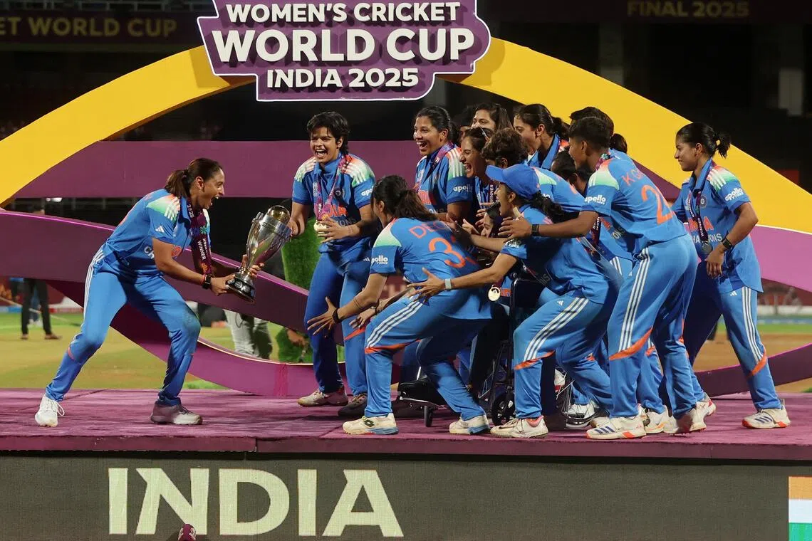 India players celebrating with the trophy after winning the Women's Cricket World Cup at DY Patil Stadium in Mumbai on Nov 2, 2025. The hosts defeated South Africa by 52 runs.