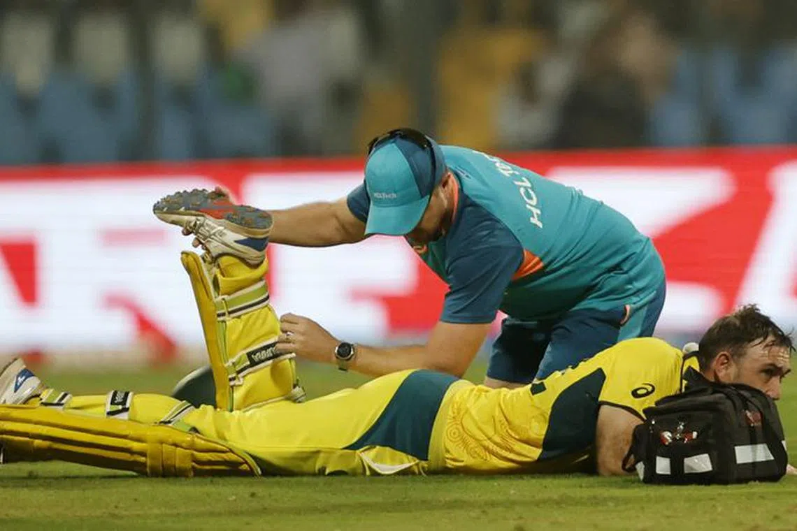 Cricket - ICC Cricket World Cup 2023 - Australia v Afghanistan - Wankhede Stadium, Mumbai, India - November 7, 2023 Australia's Glenn Maxwell receives medical attention after sustaining an injury REUTERS/Francis Mascarenhas
