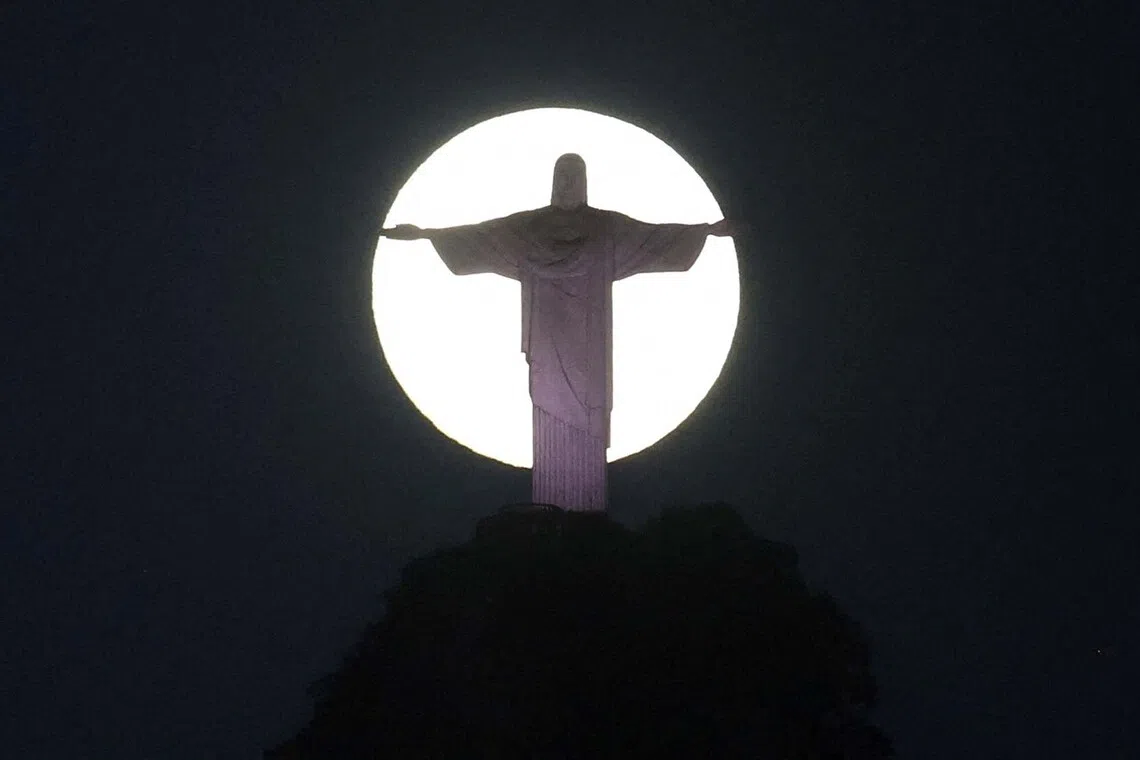 The moon shines behind the Christ the Redeemer statue in Rio de Janeiro, Brazil July 30, 2026. REUTERS/Pilar Olivares TPX IMAGES OF THE DAY