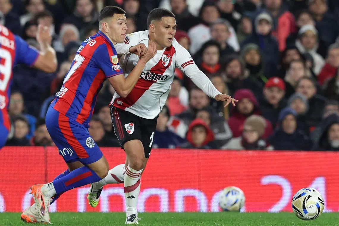 San Lorenzo defender Elias Baez (left) and River Plate's Colombian midfielder Juan Fernando Quintero fight for the ball in the Argentine Professional Football League 2025 Clausura Tournament at Monumental Stadium in Buenos Aires on July 27, 2025.