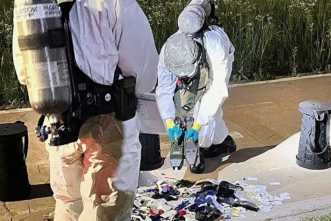 This handout photo taken by the South Korean Defence Ministry between the night of June 1 and 2, 2024 and released on June 2, shows South Korean military officers checking unidentified objects believed to be North Korean trash from balloons that crossed the inter-Korea border, on a street in Seoul. 