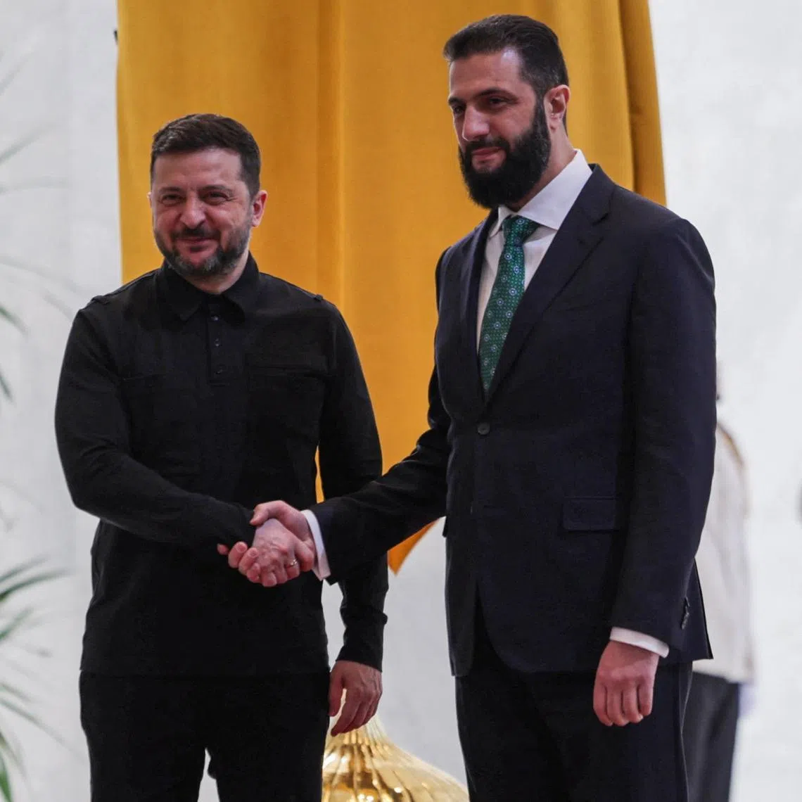 Ukraine's President Volodymyr Zelenskiy shakes hands with Syria's President Ahmed al-Sharaa as they meet in Damascus, Syria, April 5, 2026. REUTERS/Khalil Ashawi