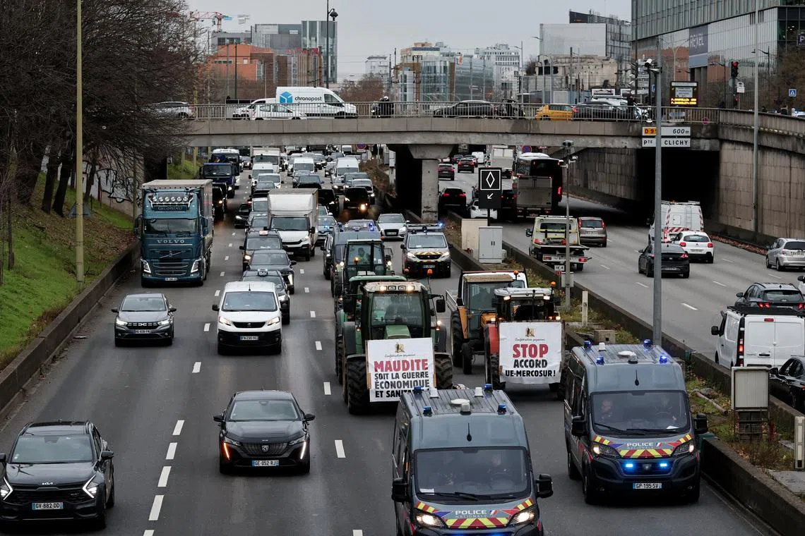 French farmers of the Confederation Paysanne drive their tractors slowly on the Paris ring road during a \"Go Slow\" protest against the government's handling of the EU-Mercosur free trade agreement and the handling of the lumpy skin disease outbreak, in Paris, France, January 9, 2026. The slogans read  \"Damn this economic and health war\" and \"Stop the EU-Mercosur agreement\".  REUTERS/Benoit Tessier