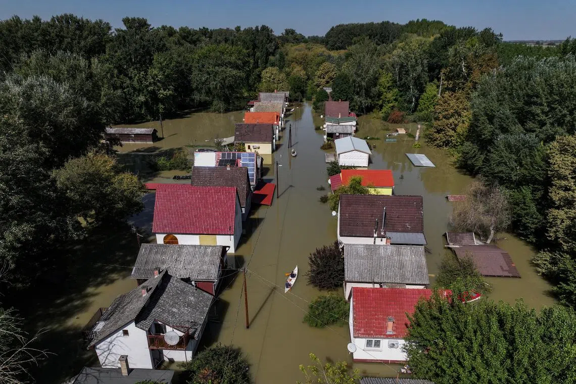 FILE PHOTO: A drone view shows a man rowing a boat among houses flooded by the Danube River in the village of Ersekcsanad, Hungary, September 22, 2024. REUTERS/Marko Djurica/File Photo