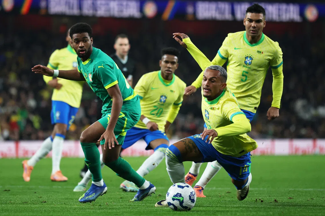 Brazil's Wesley Franca and Casemiro in action with Senegal's Ibrahim Mbaye.
